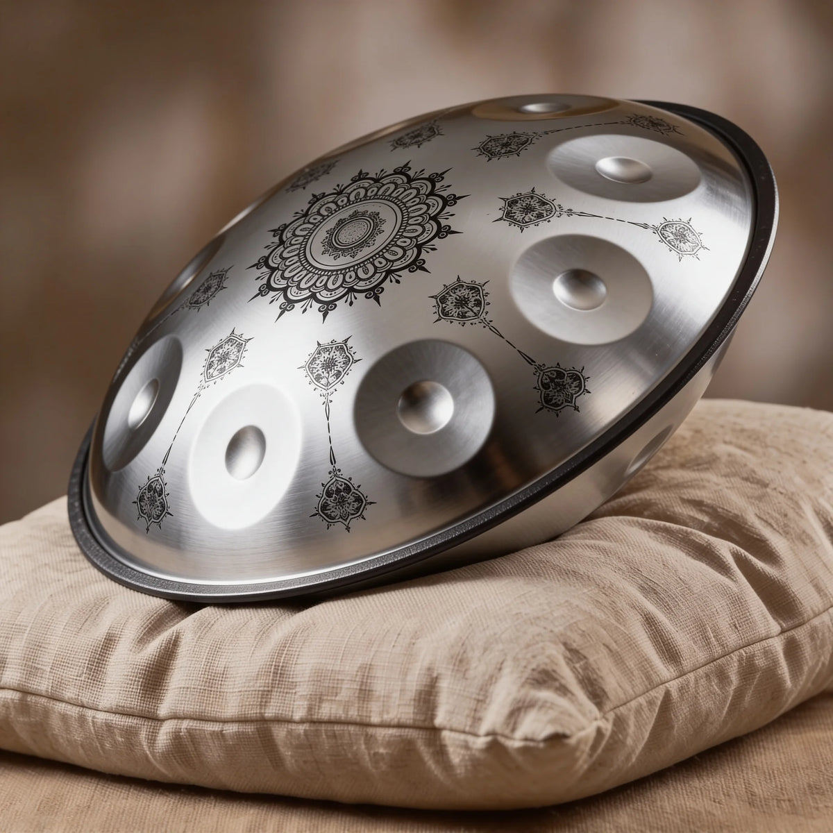 Handpan Celtic Minor Lumandala Kovapan acier, motifs mandala henné, posé sur coussin lin