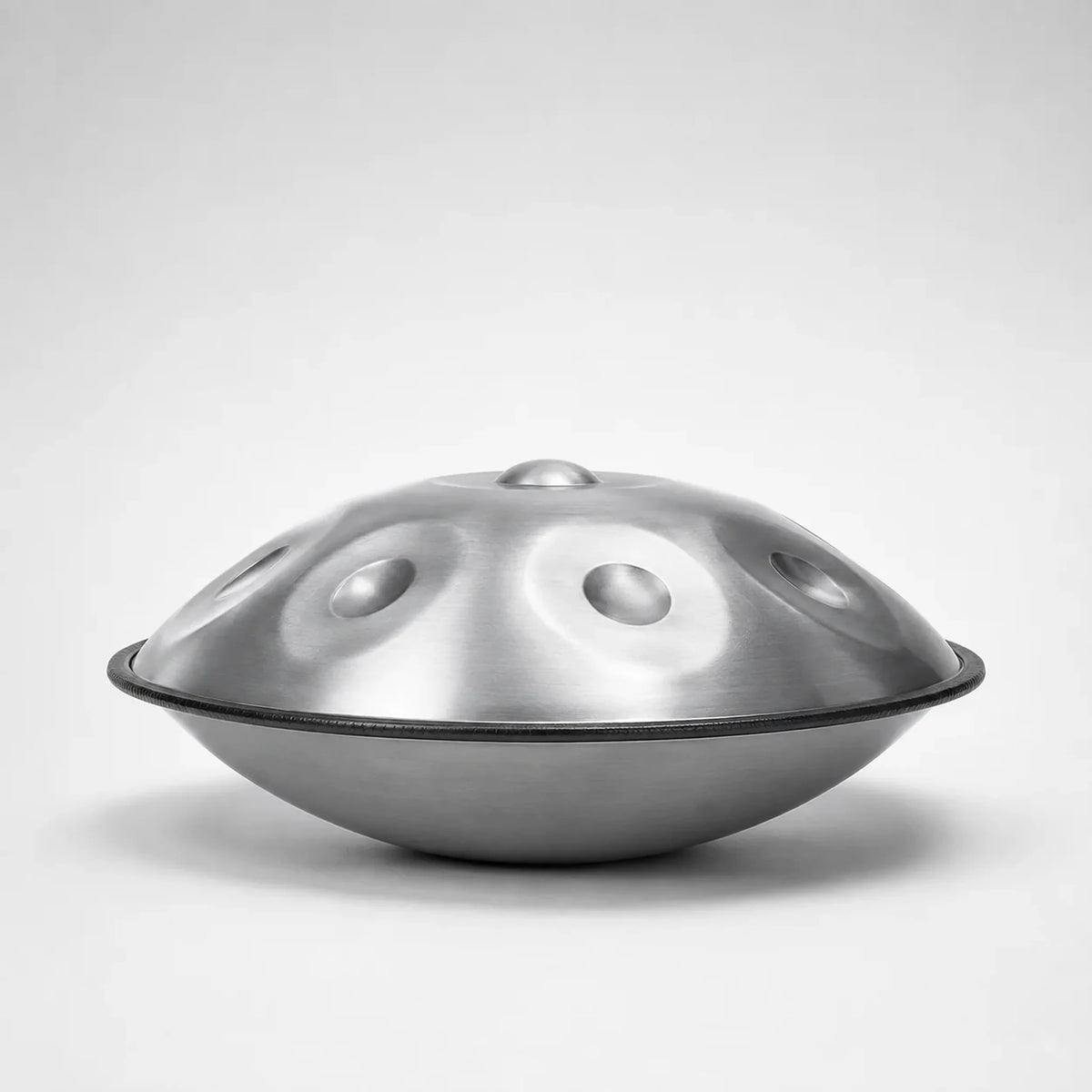 Handpan STELLAR argenté vu de profil sur fond gris neutre – Kovapan
