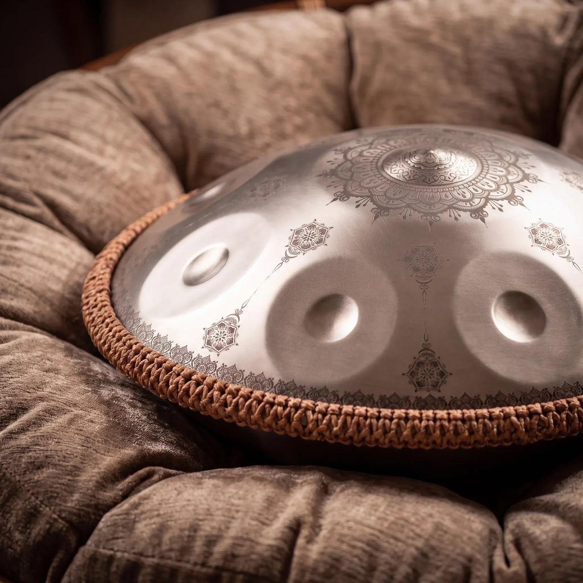 Handpan G Minor mandala CLAIRIÈRE argenté posé sur coussin velours, bord tressé naturel – Kovapan