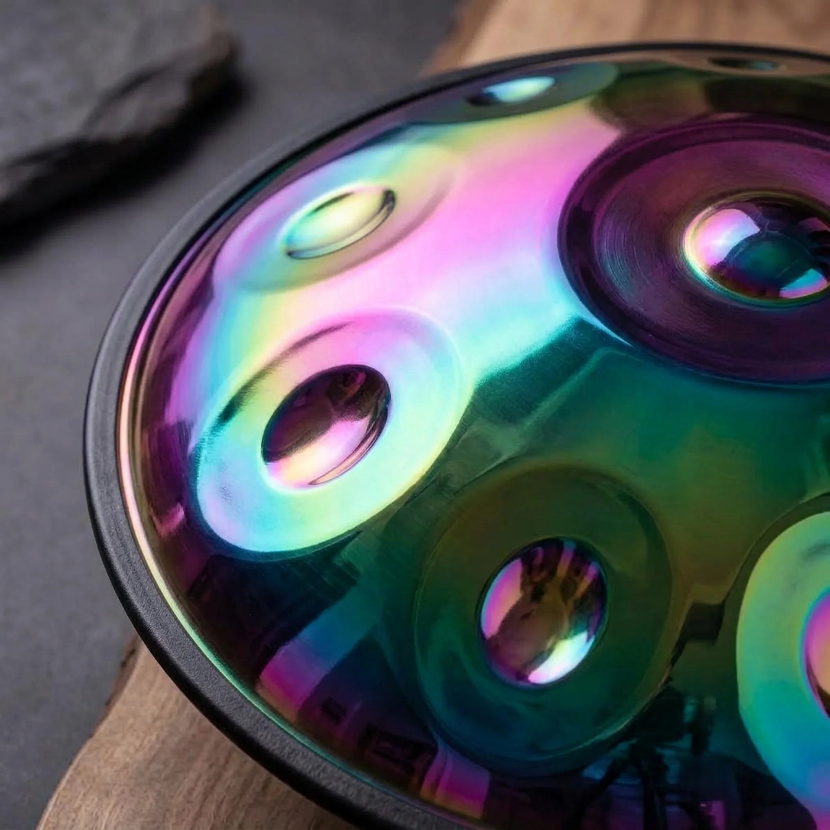 Handpan Harmonie iridescent – gros plan champs de notes reflets arc-en-ciel rose vert sur bois et ardoise – Kovapan