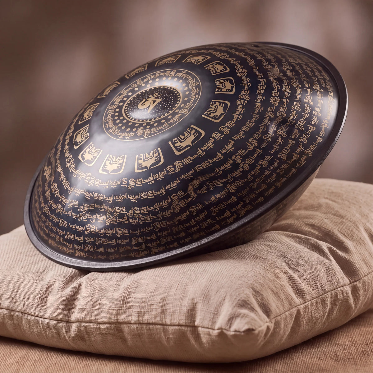 Handpan haut de gamme noir Kovapan – posé de profil sur coussin lin fond bokeh chaud
