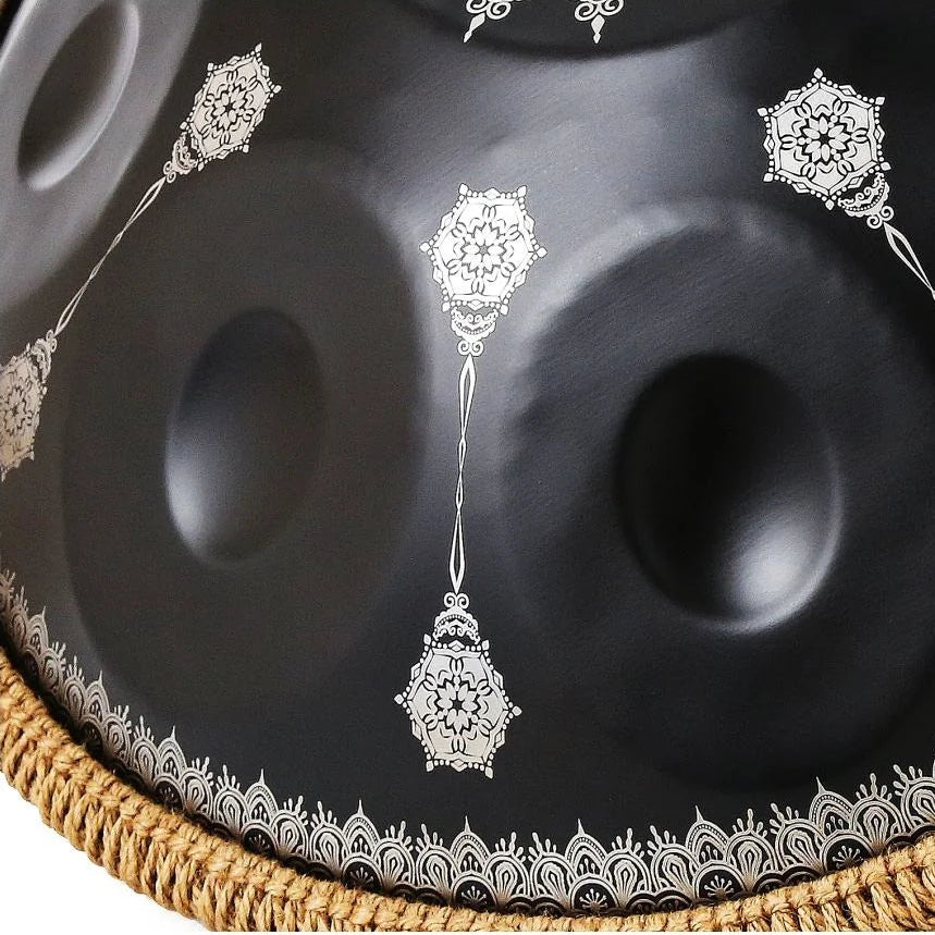 Gros plan des champs de notes du handpan OBSIDIENNE noir, motifs mandala argentés et bordure en corde naturelle – Kovapan