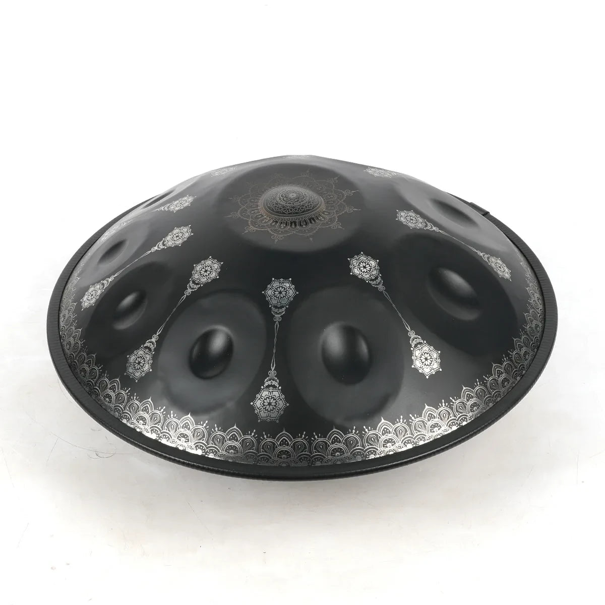 Handpan OBSIDIENNE noir mat vu de trois quarts, motifs mandala argentés et pendentifs entre les champs de notes – Kovapan