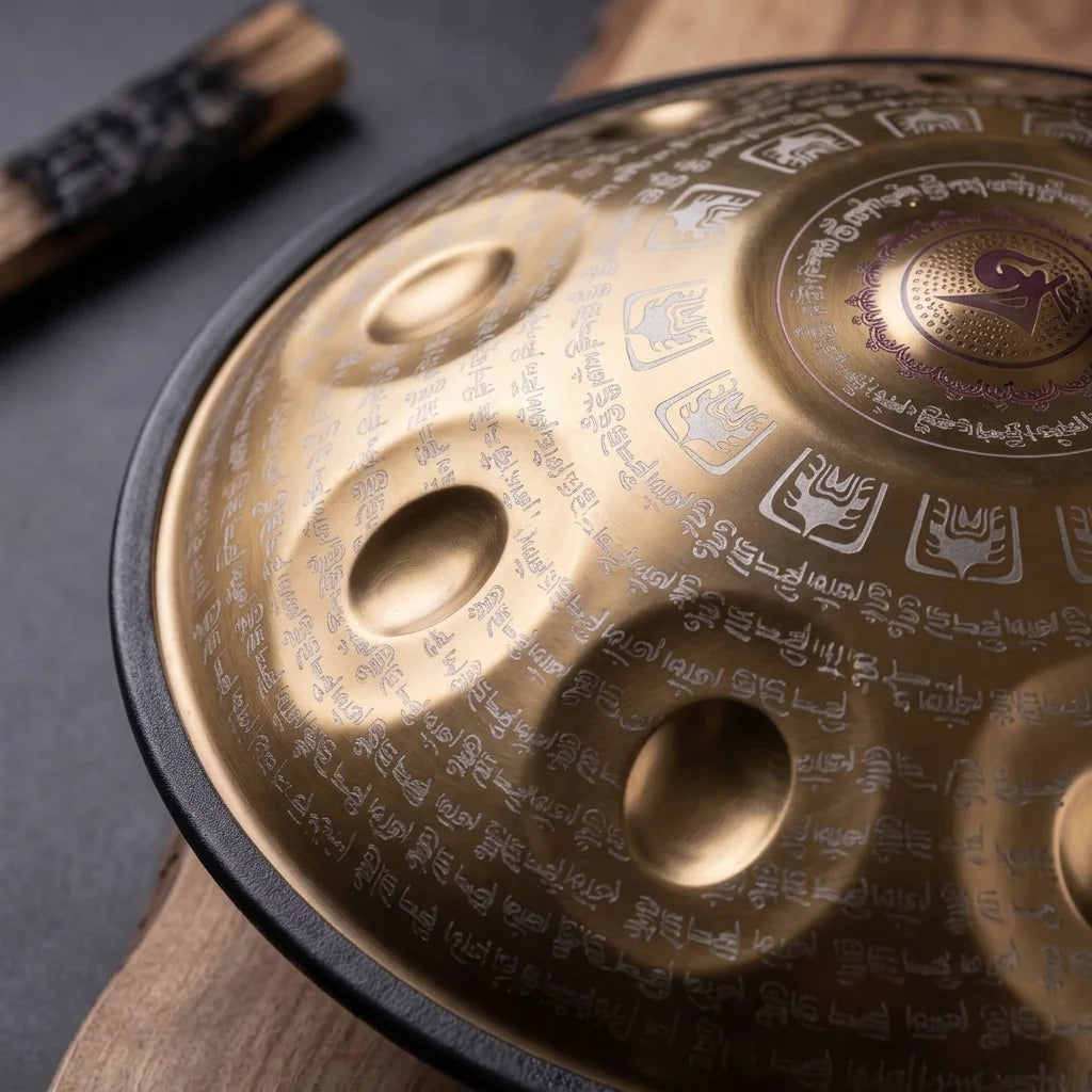 Handpan TALISMAN doré, gros plan sur les champs de notes et la calligraphie gravée – Kovapan