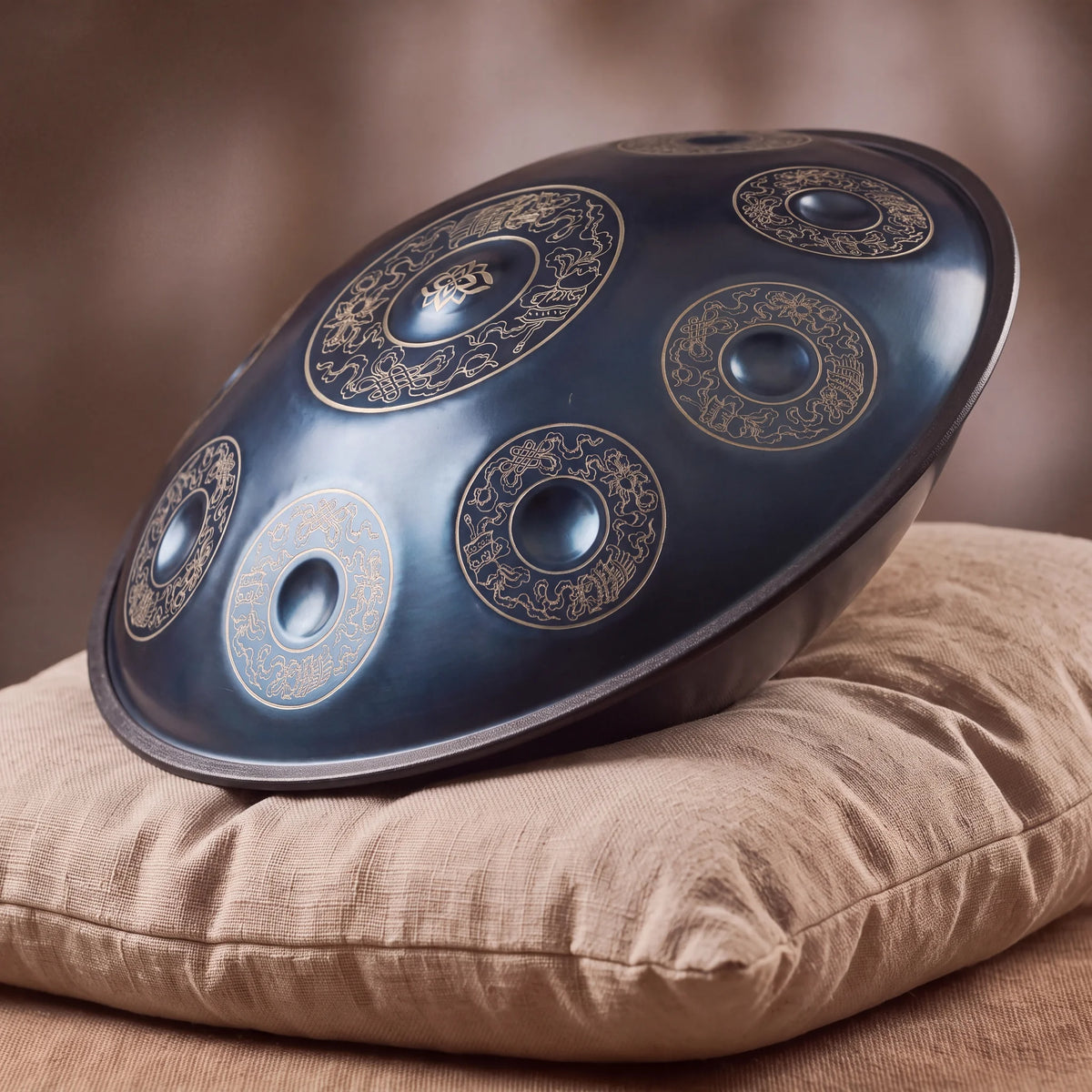 Handpan D Kurd 10 notes Brume Kovapan – posé de profil sur coussin lin fond bokeh chaud