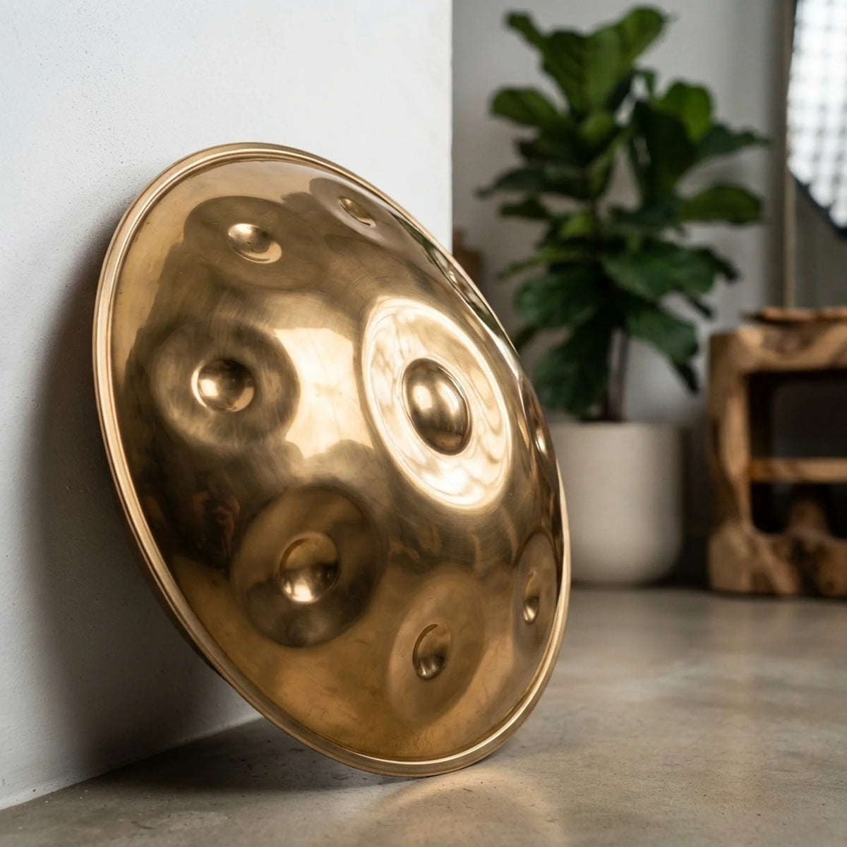 Handpan instrument de musique SOLAS doré poli appuyé contre un mur – Kovapan