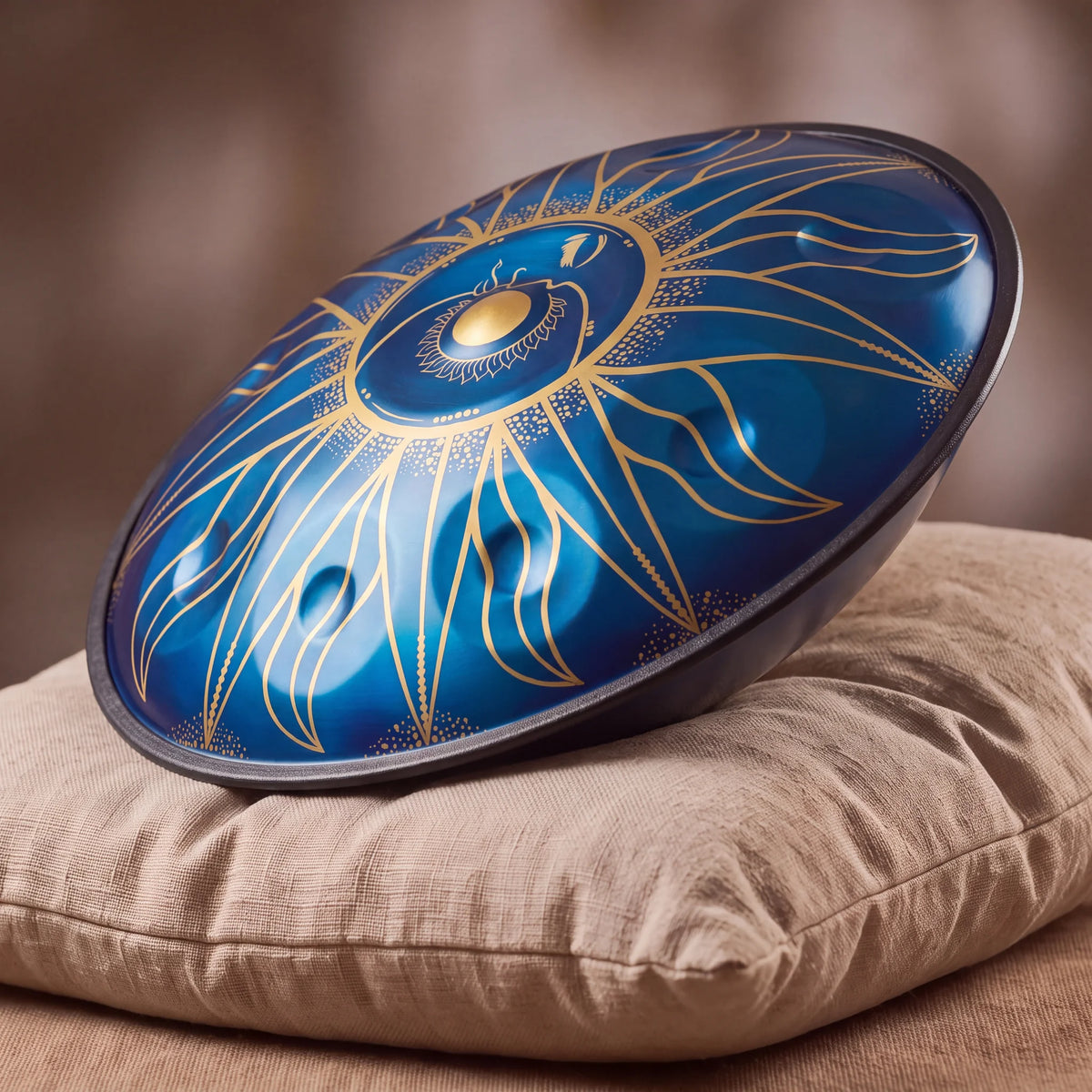 Handpan D Kurd Eclipse bleu Kovapan gravures dorées – posé de profil sur coussin lin fond bokeh