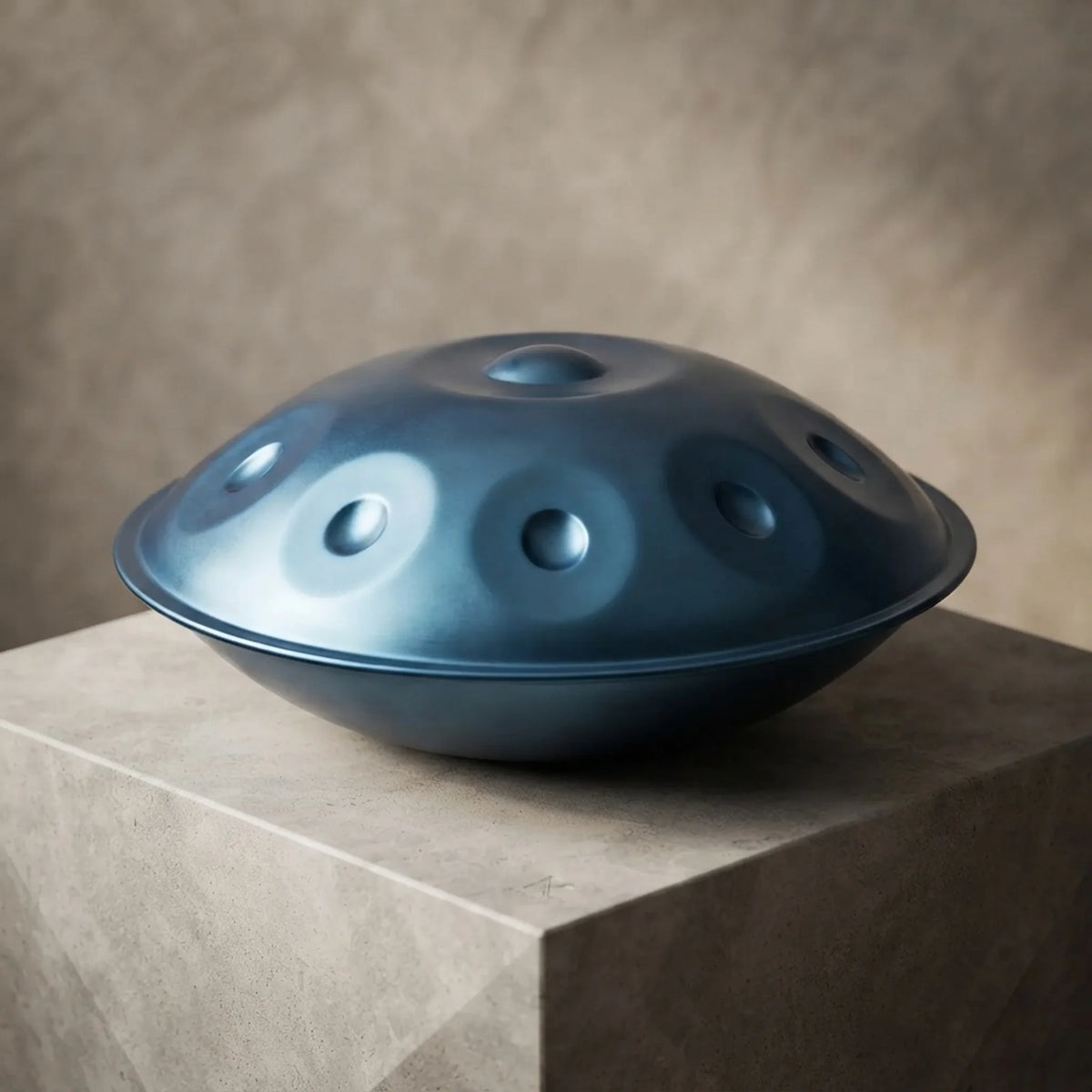 Handpan Equinox bleu – posé de profil sur bloc béton ambiance minimaliste – Kovapan
