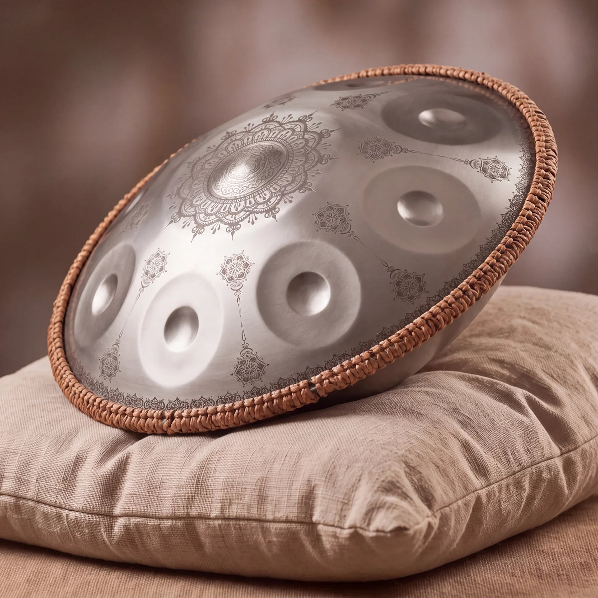 Handpan G Minor mandala CLAIRIÈRE argenté en Sol mineur, posé de profil sur coussin de lin – Kovapan