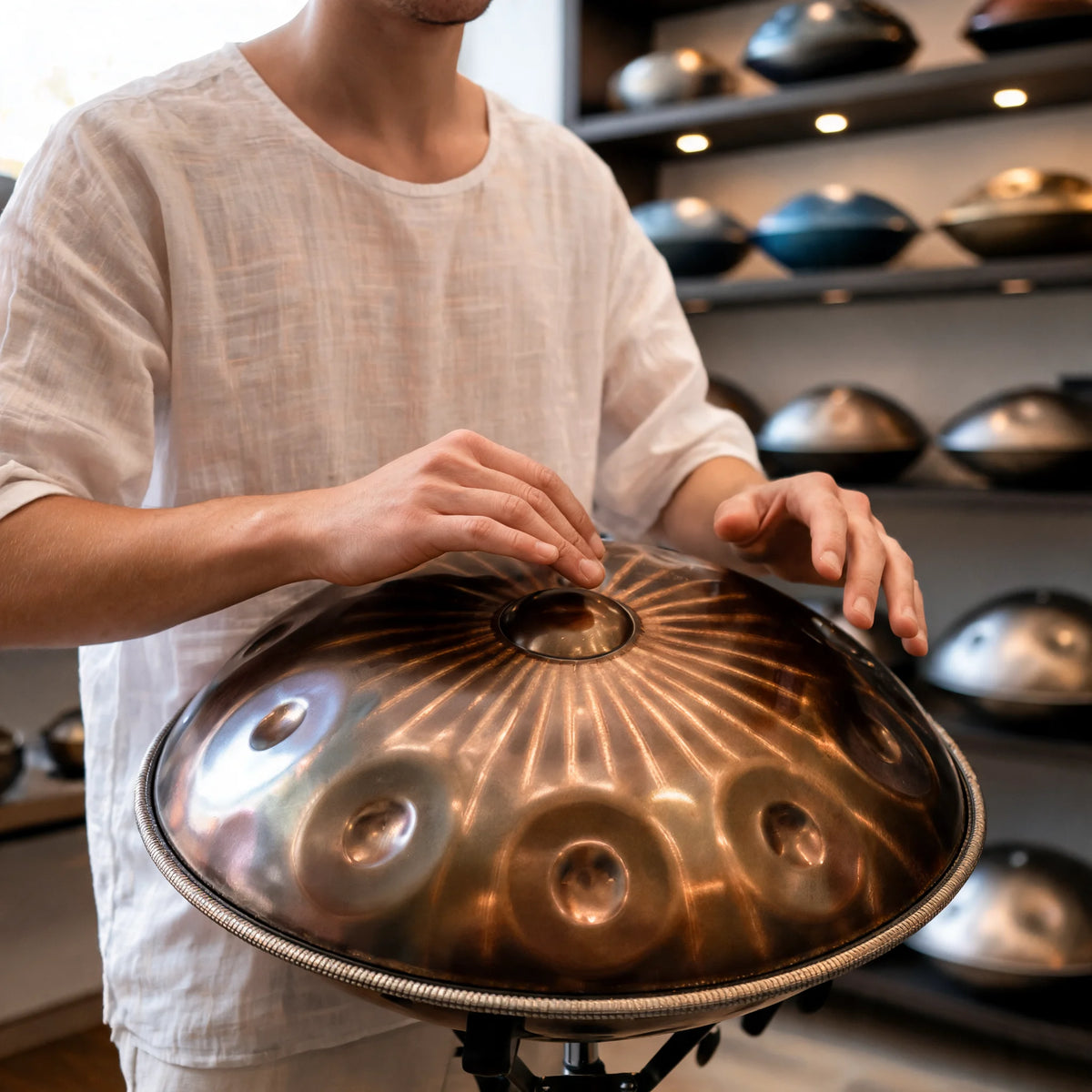 Handpan SAVANE 9 notes joué à la main, posé sur un support trépied – Kovapan
