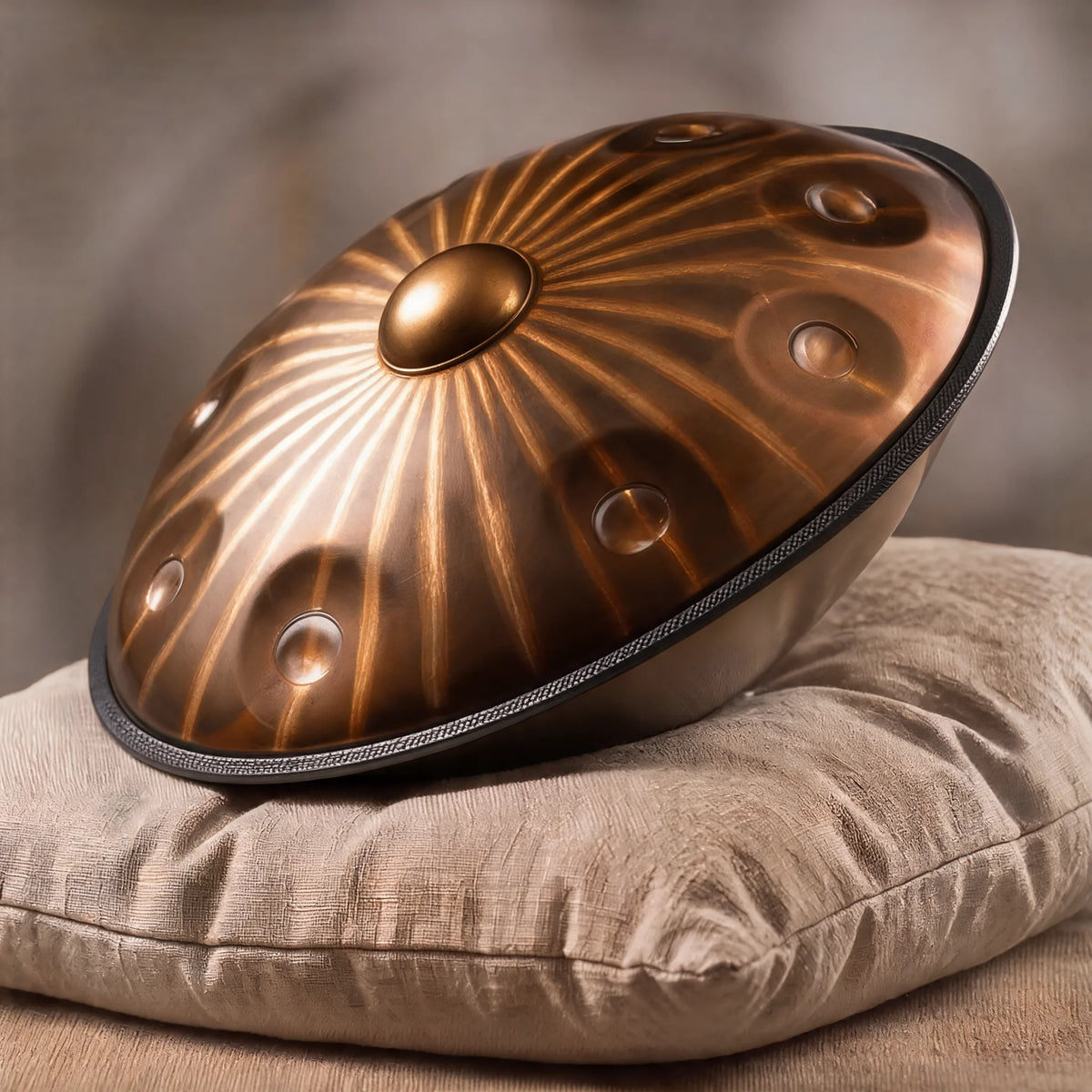 Handpan SAVANE en Ré mineur, finition bronze, posé sur un coussin en lin, rayons gravés autour du Ding – Kovapan