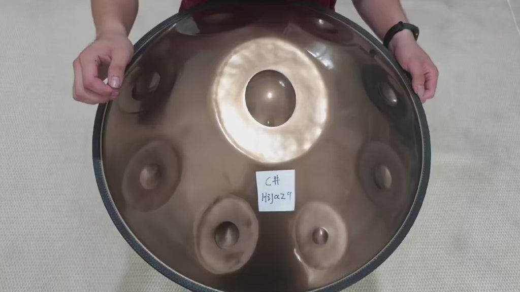 Handpan C# SIMOUN en Do dièse Hijaz, finition or, joué à la main vu de dessus – Kovapan
