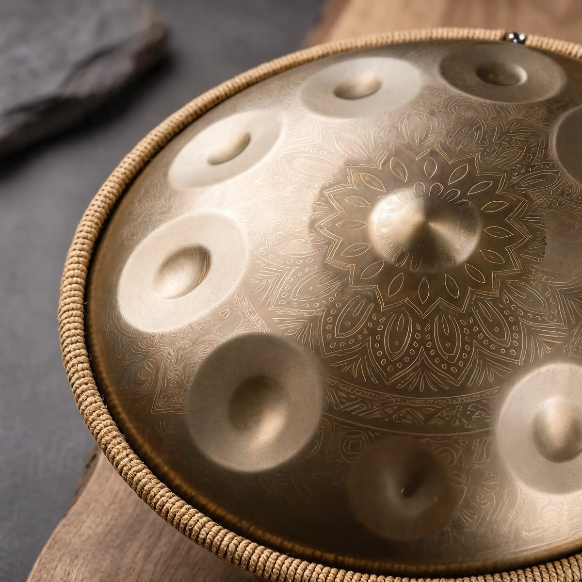 Gros plan sur la gravure mandala et les champs de notes du tambour handpan DUNE doré, cerclage tressé – Kovapan